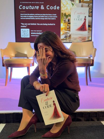 Sonia Aslam laughing, a copy of Couture & Code on her knee