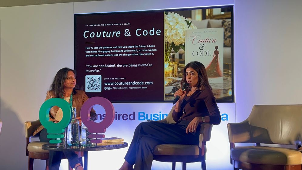 Sonia Aslam in conversation on stage, with the Couture & Code slide behind her